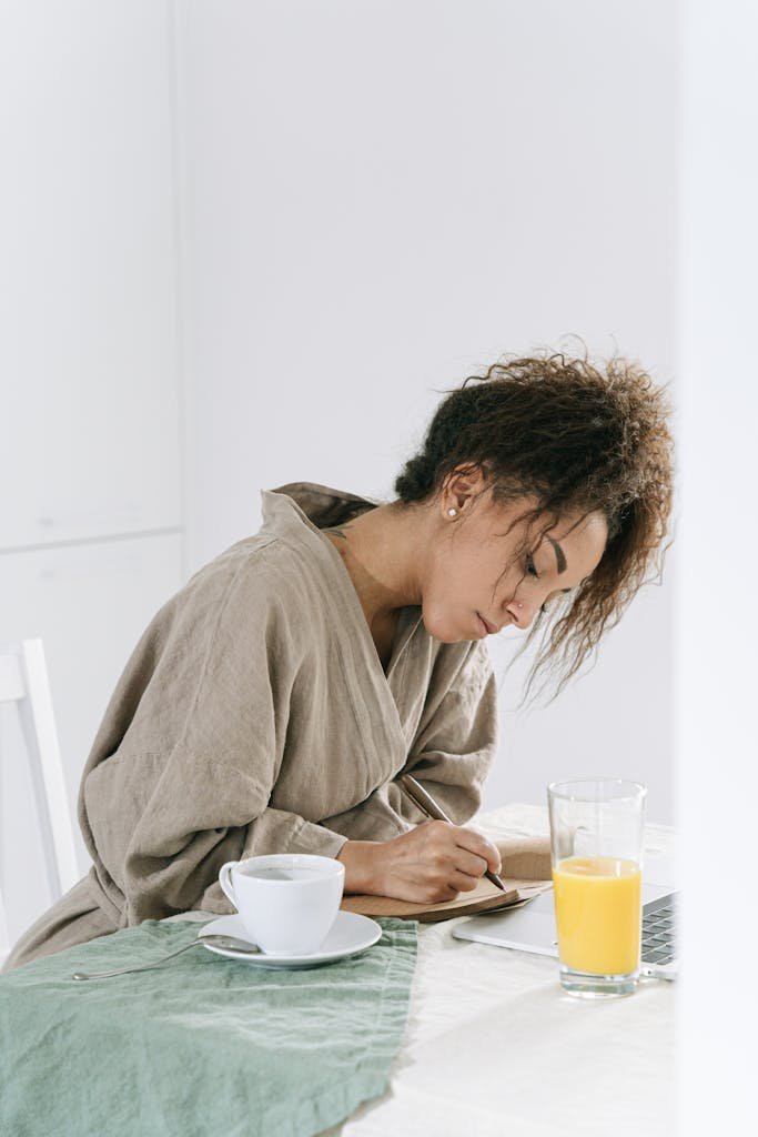 Woman in Brown Bathrobe writing on a Journal #intentional living